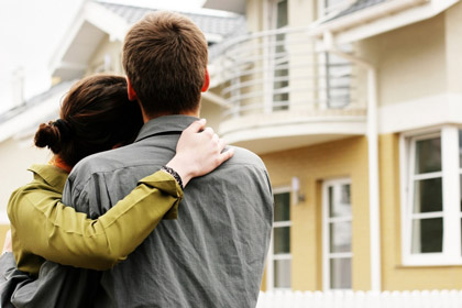 przytulająca się para patrząca na dom
